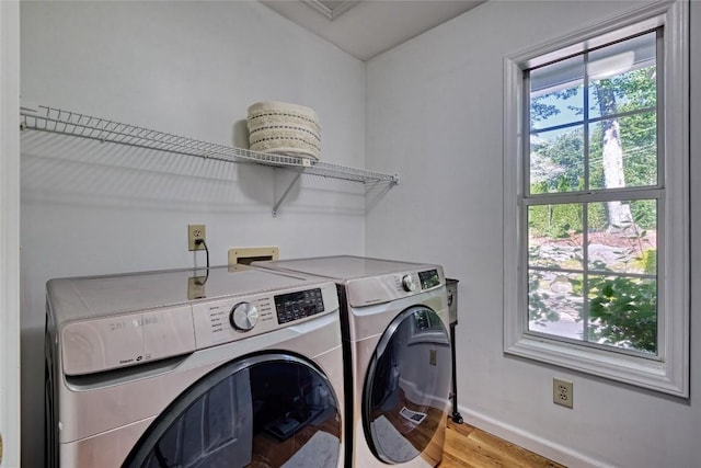 laundry area featuring laundry area, separate washer and dryer, light wood finished floors, and baseboards