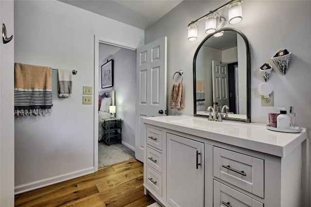bathroom with baseboards, vanity, and wood finished floors