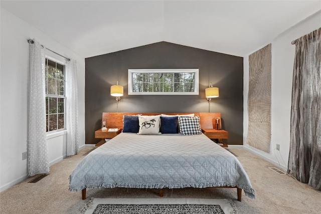 bedroom featuring visible vents, multiple windows, vaulted ceiling, and carpet floors