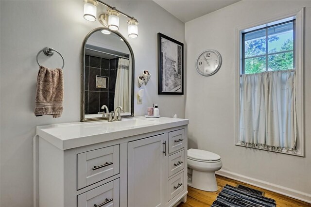 full bath featuring visible vents, baseboards, toilet, vanity, and wood finished floors