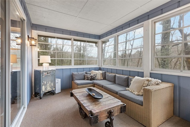 sunroom / solarium featuring an outdoor living space, a decorative wall, and carpet floors