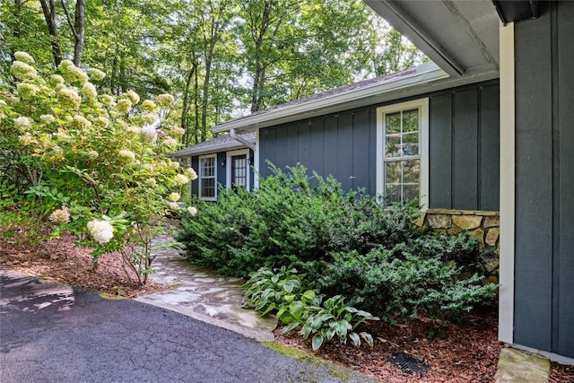 view of side of property featuring board and batten siding and stone siding
