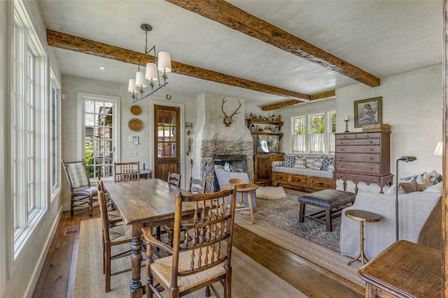 168 Old Wagon Rd, Highlands, NC 28741 - dining space with wood-type flooring, a stone fireplace, beamed ceiling, and a chandelier
