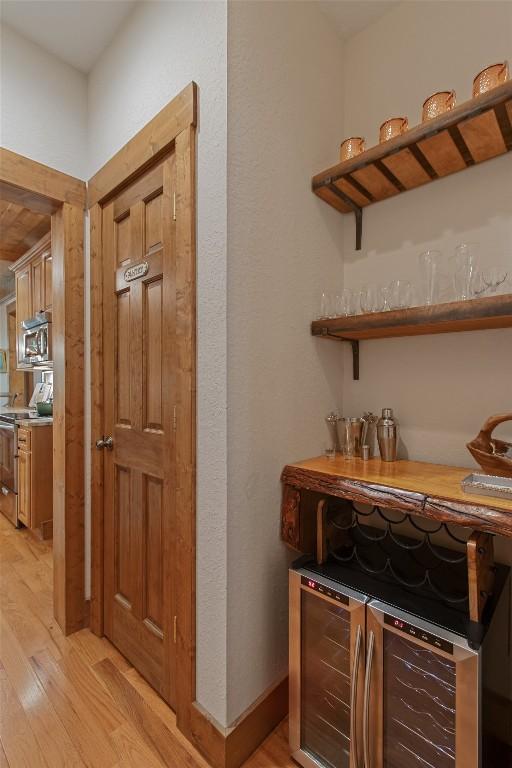 161 Kestrel Ct, Sapphire, NC 28774 - indoor dry bar featuring appliances with stainless steel finishes, light wood finished floors, and beverage cooler