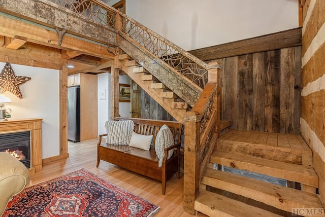 stairway with hardwood / wood-style flooring, a high ceiling, and wooden walls