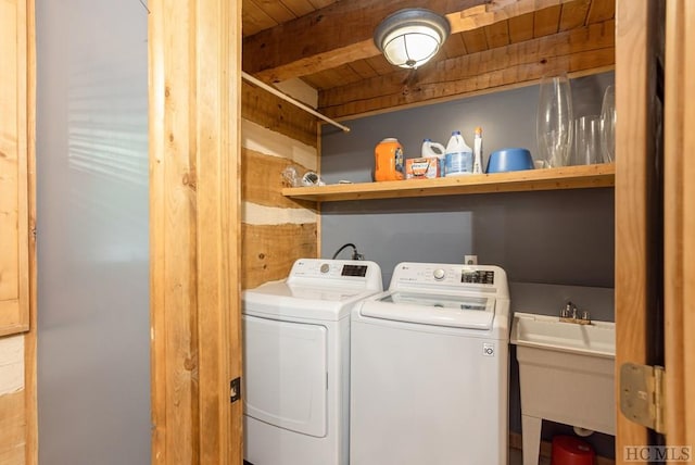 clothes washing area featuring washer and clothes dryer, sink, and wooden ceiling