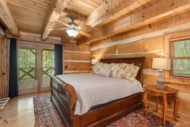 bedroom with wood ceiling, wooden walls, access to outside, beamed ceiling, and multiple windows