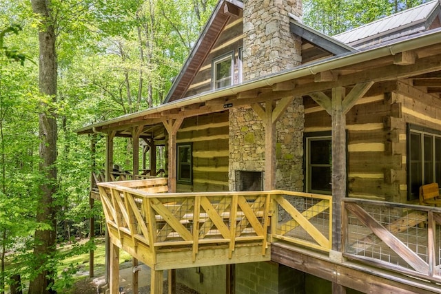 view of side of property with metal roof, a chimney, and a deck