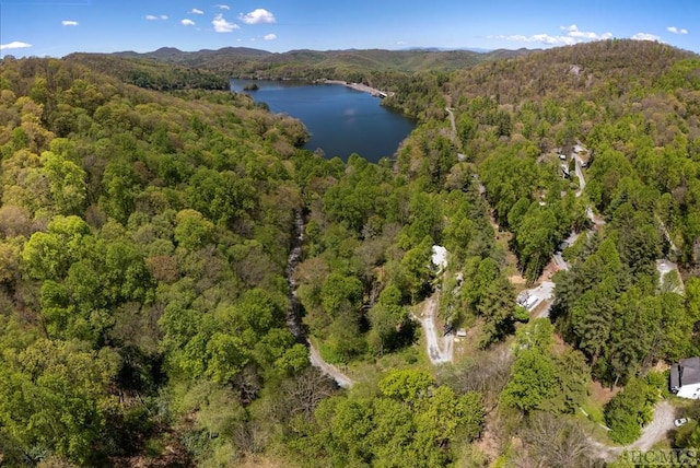 aerial view of property and surrounding area with a forest and a water and mountain view
