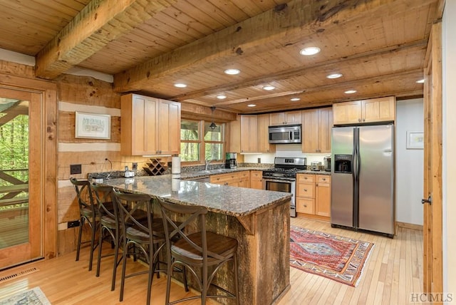 kitchen with beamed ceiling, dark stone counters, kitchen peninsula, stainless steel appliances, and wooden ceiling