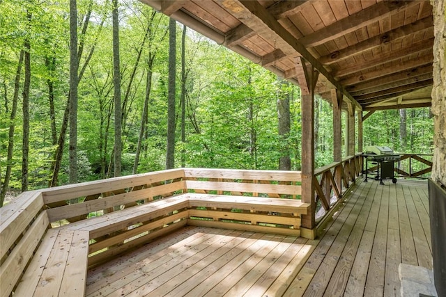 wooden deck featuring grilling area and a forest view