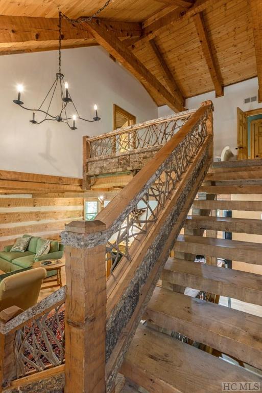 stairway featuring wooden ceiling, a chandelier, high vaulted ceiling, beam ceiling, and wood-type flooring
