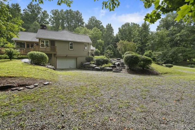 view of yard featuring a garage and a wooden deck