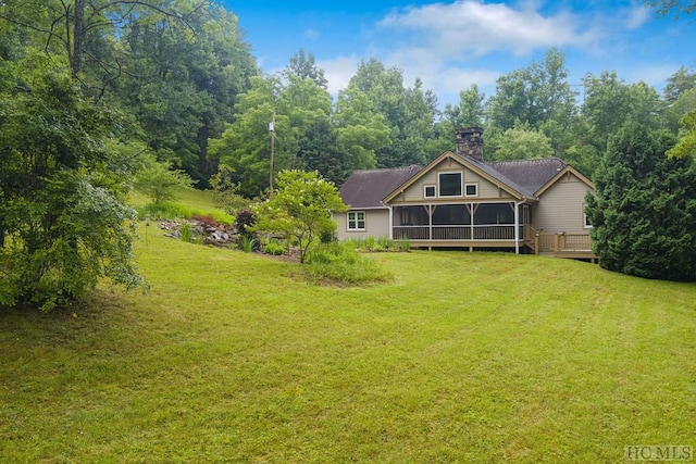 back of house featuring a yard and a sunroom