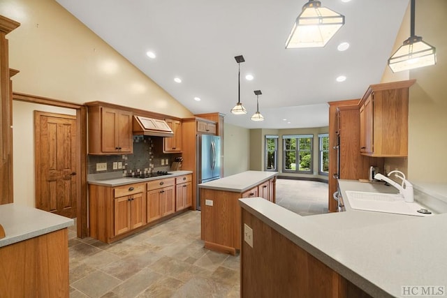 kitchen featuring hanging light fixtures, a kitchen island, stainless steel refrigerator, sink, and black electric stovetop