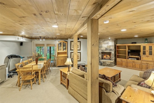 carpeted living room with wood ceiling, a fireplace, rail lighting, and french doors