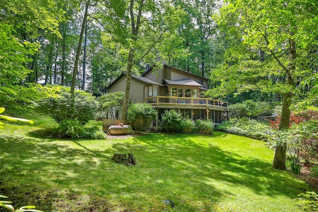 back of house featuring a deck and a lawn