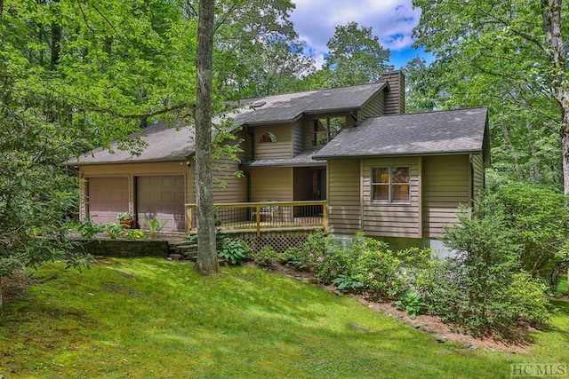 back of house with a garage and a lawn