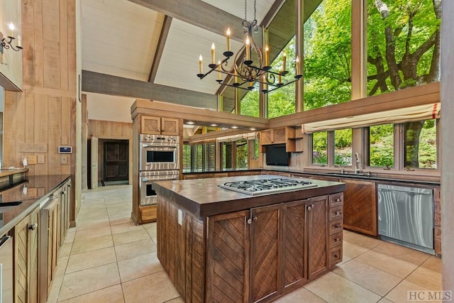 kitchen featuring sink, light tile patterned floors, high vaulted ceiling, and stainless steel appliances