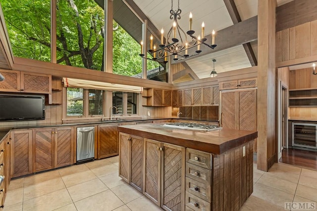 kitchen with stainless steel gas cooktop, light tile patterned flooring, wood counters, and high vaulted ceiling