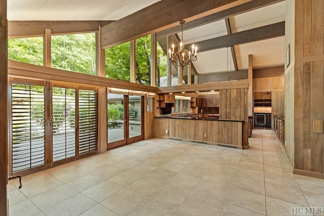 kitchen with pendant lighting, light tile patterned floors, an inviting chandelier, high vaulted ceiling, and kitchen peninsula