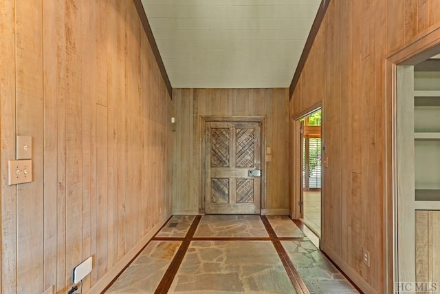 entryway with wood walls