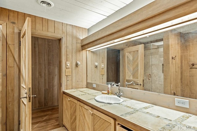 bathroom with vanity and wood walls