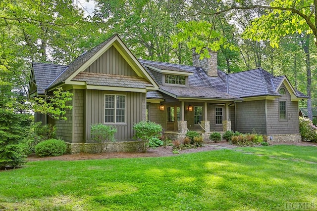 craftsman-style house featuring covered porch and a front lawn