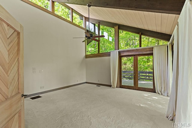 carpeted empty room featuring ceiling fan, lofted ceiling with beams, and wooden ceiling