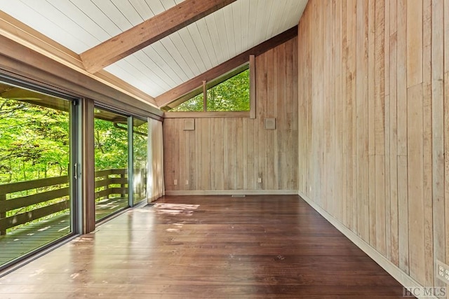 interior space with wood walls, a healthy amount of sunlight, dark hardwood / wood-style floors, and vaulted ceiling with beams