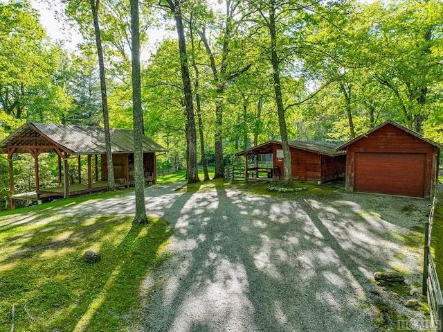 view of yard featuring a garage and an outbuilding