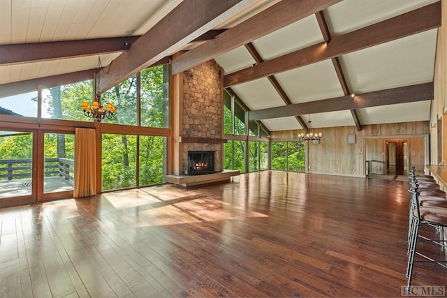 interior space with high vaulted ceiling, a notable chandelier, a fireplace, wood-type flooring, and beamed ceiling