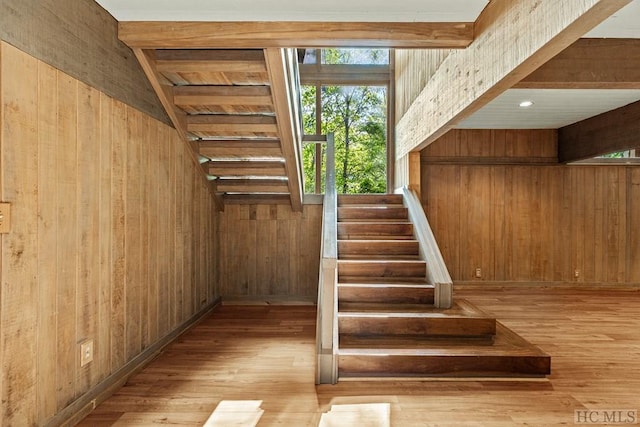 staircase with hardwood / wood-style flooring and wood walls