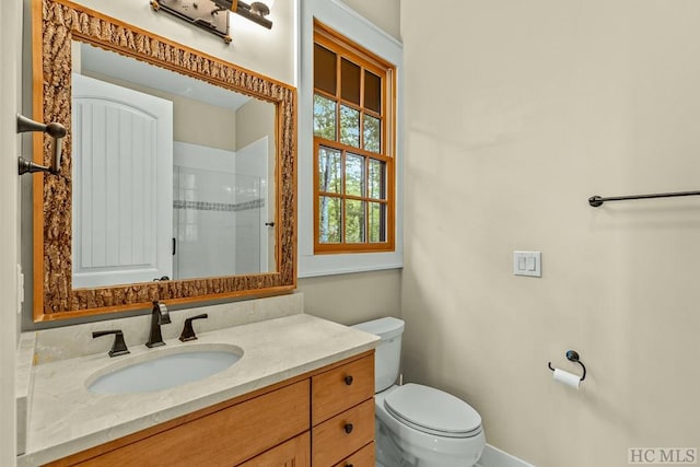 bathroom featuring vanity, toilet, and an enclosed shower