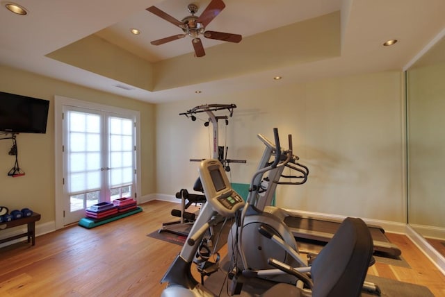 exercise room featuring recessed lighting, a raised ceiling, a ceiling fan, visible vents, and wood finished floors