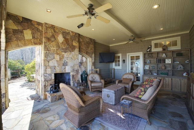 view of patio featuring an outdoor living space with a fireplace and a ceiling fan