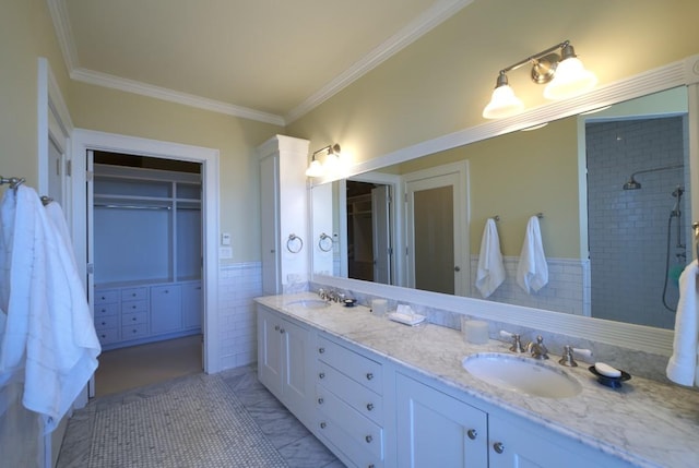 bathroom with crown molding, double vanity, a sink, and tile walls