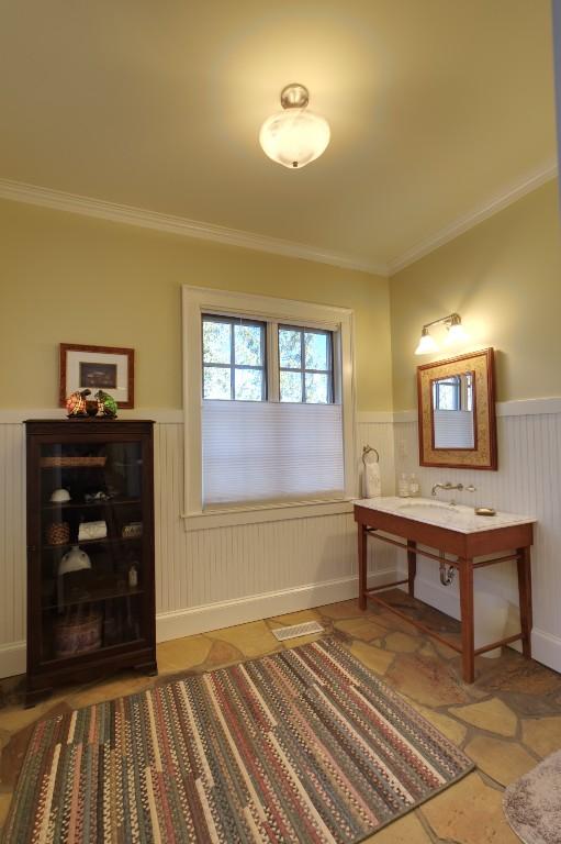 interior space featuring crown molding and wainscoting