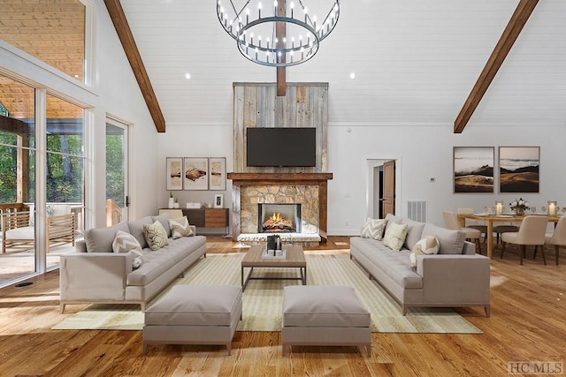 living room featuring a fireplace, beam ceiling, light hardwood / wood-style flooring, and high vaulted ceiling