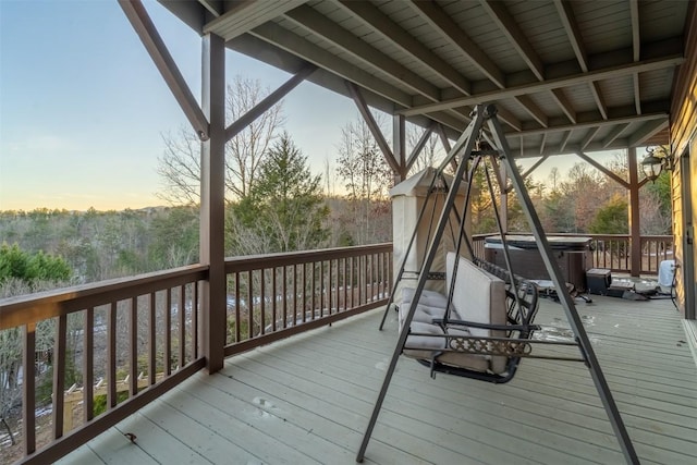 deck at dusk with a hot tub