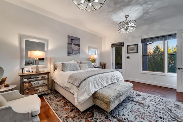 bedroom with hardwood / wood-style flooring and a chandelier