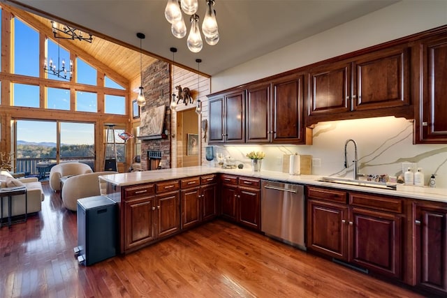 kitchen with pendant lighting, dishwasher, sink, a chandelier, and kitchen peninsula