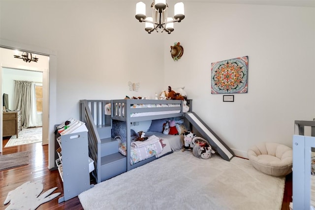 bedroom with dark hardwood / wood-style floors and a notable chandelier