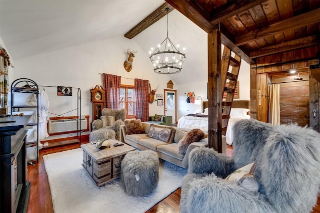 living room featuring hardwood / wood-style flooring, vaulted ceiling with beams, a notable chandelier, and wood walls