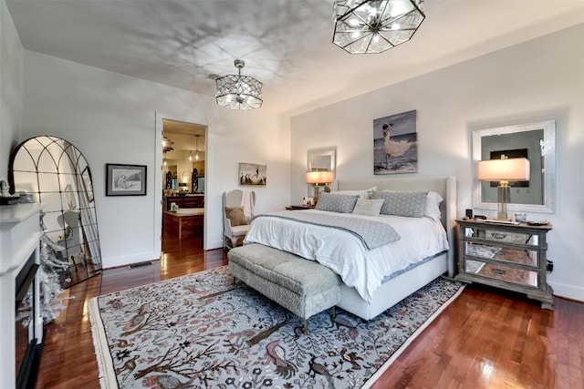 bedroom featuring an inviting chandelier and dark wood-type flooring