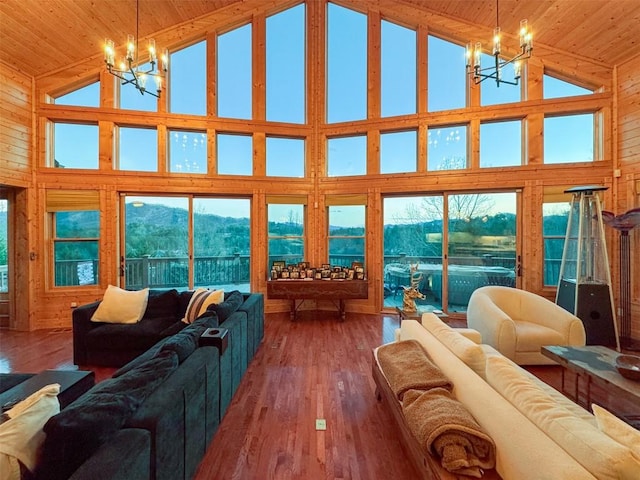 living room with high vaulted ceiling, wooden ceiling, and an inviting chandelier