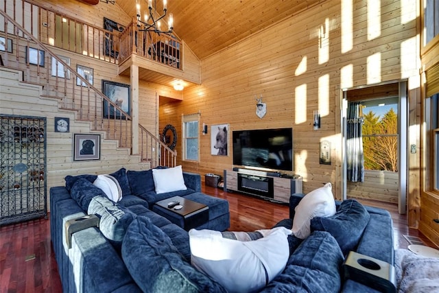 living room with wood ceiling, high vaulted ceiling, dark hardwood / wood-style floors, wooden walls, and a notable chandelier