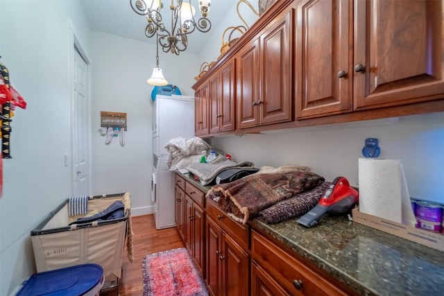 laundry area featuring an inviting chandelier, cabinets, and light wood-type flooring