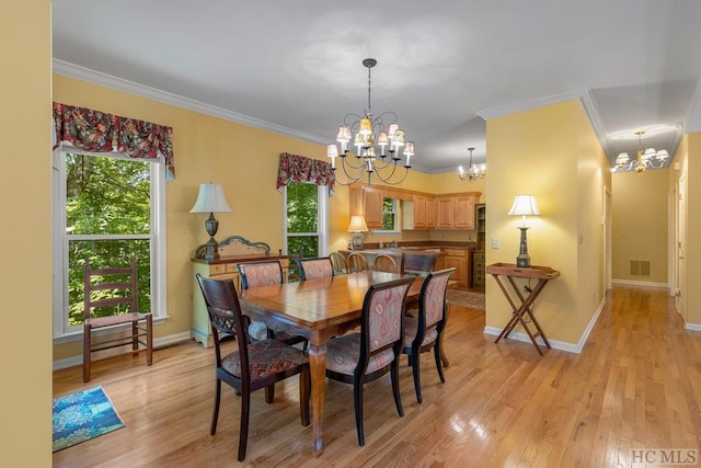 dining room featuring crown molding, plenty of natural light, a chandelier, and light hardwood / wood-style floors