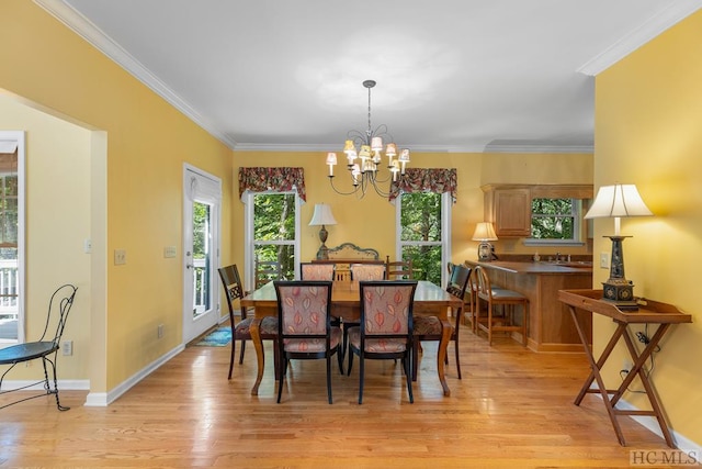 dining area featuring ornamental molding, light hardwood / wood-style floors, and a notable chandelier